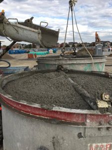 Concrete mixer loading up a crane bucket